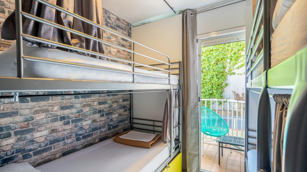 Cama en dormitorio mixto (6 camas) con Balcón Privado